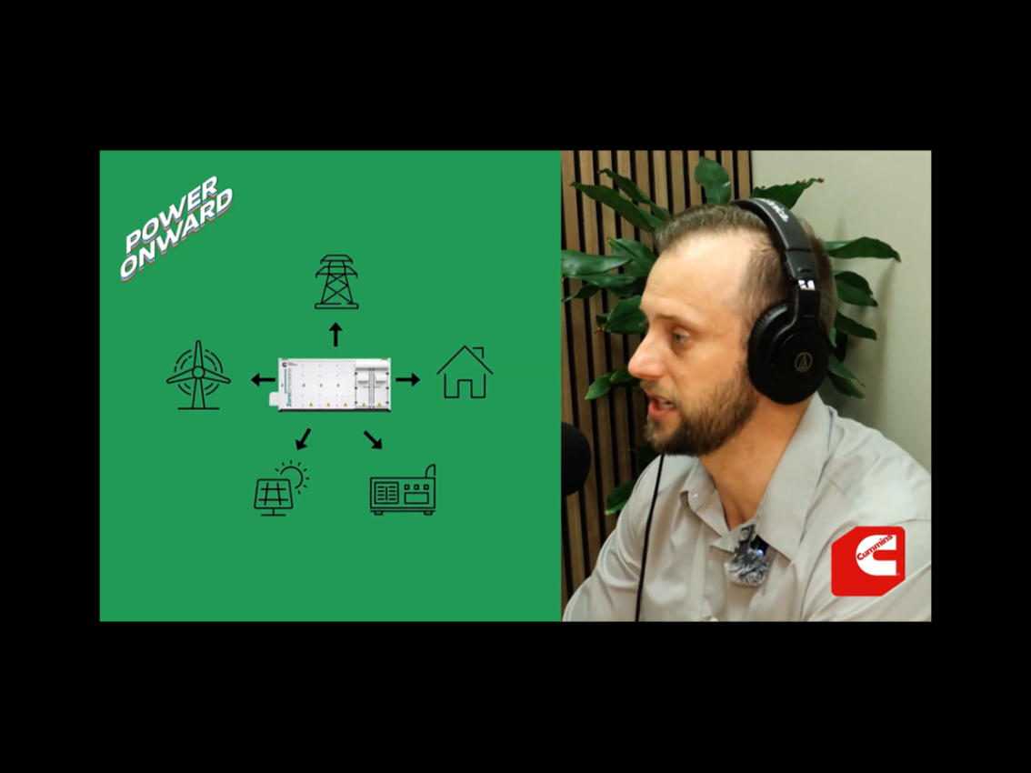 man talking in podcast studio with battery storage system graphic