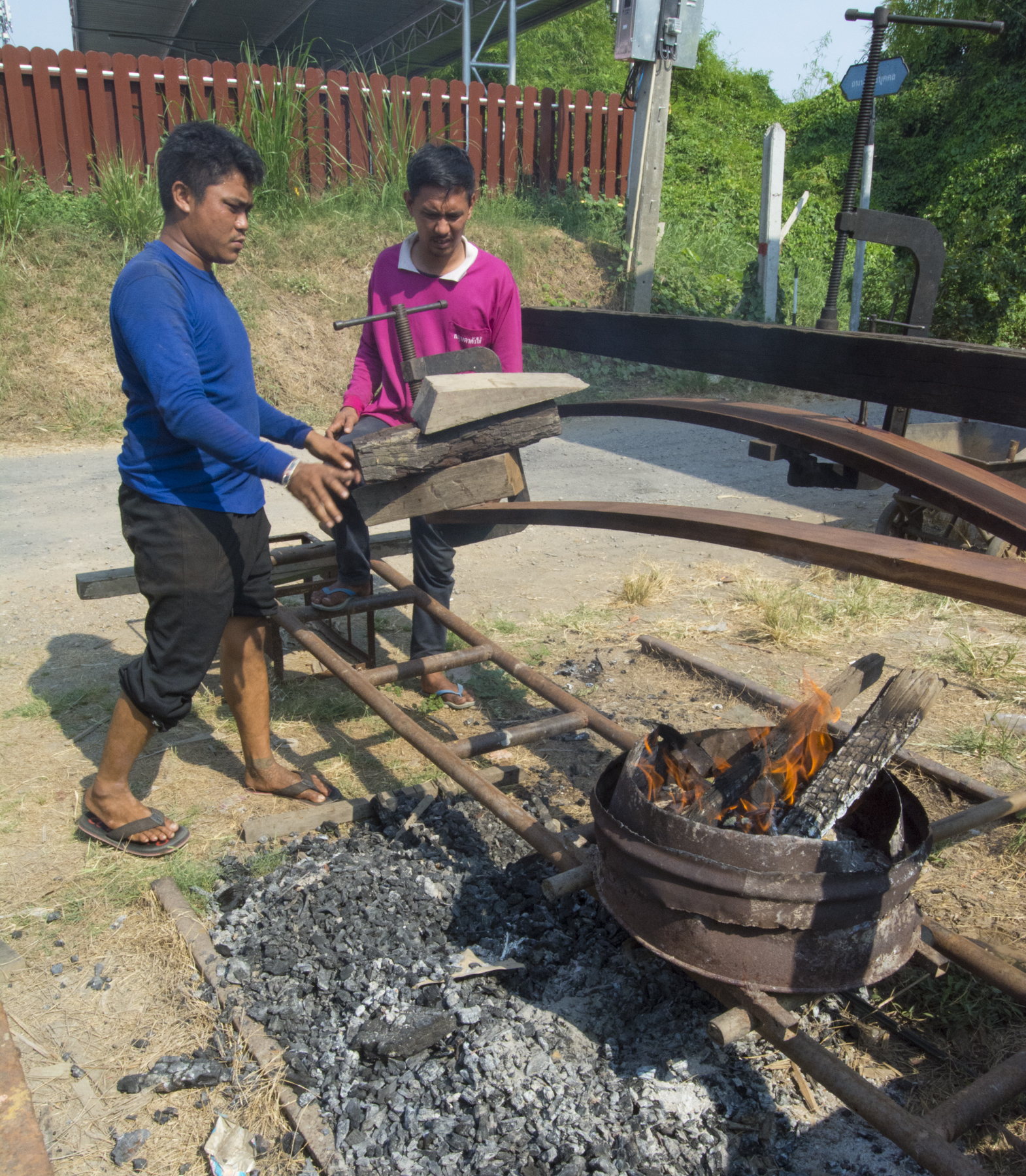 Takien wood planks are heated and bent to be put onto a barge hull.