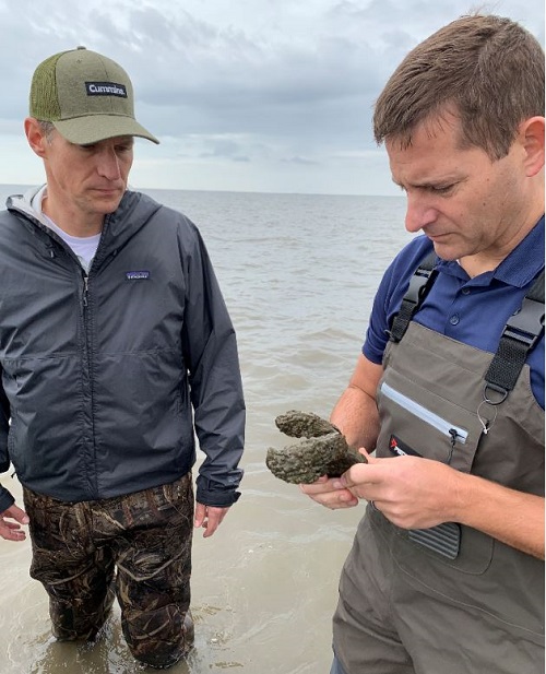 Cummins leaders Zach Gillen and Brian Mormino learn about the environmental benefits possible by restoring oyster reefs.