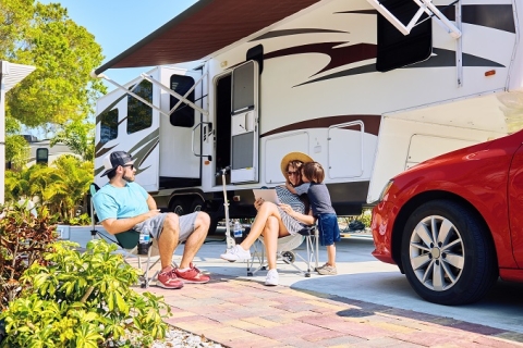 Family sitting outside RV mounted