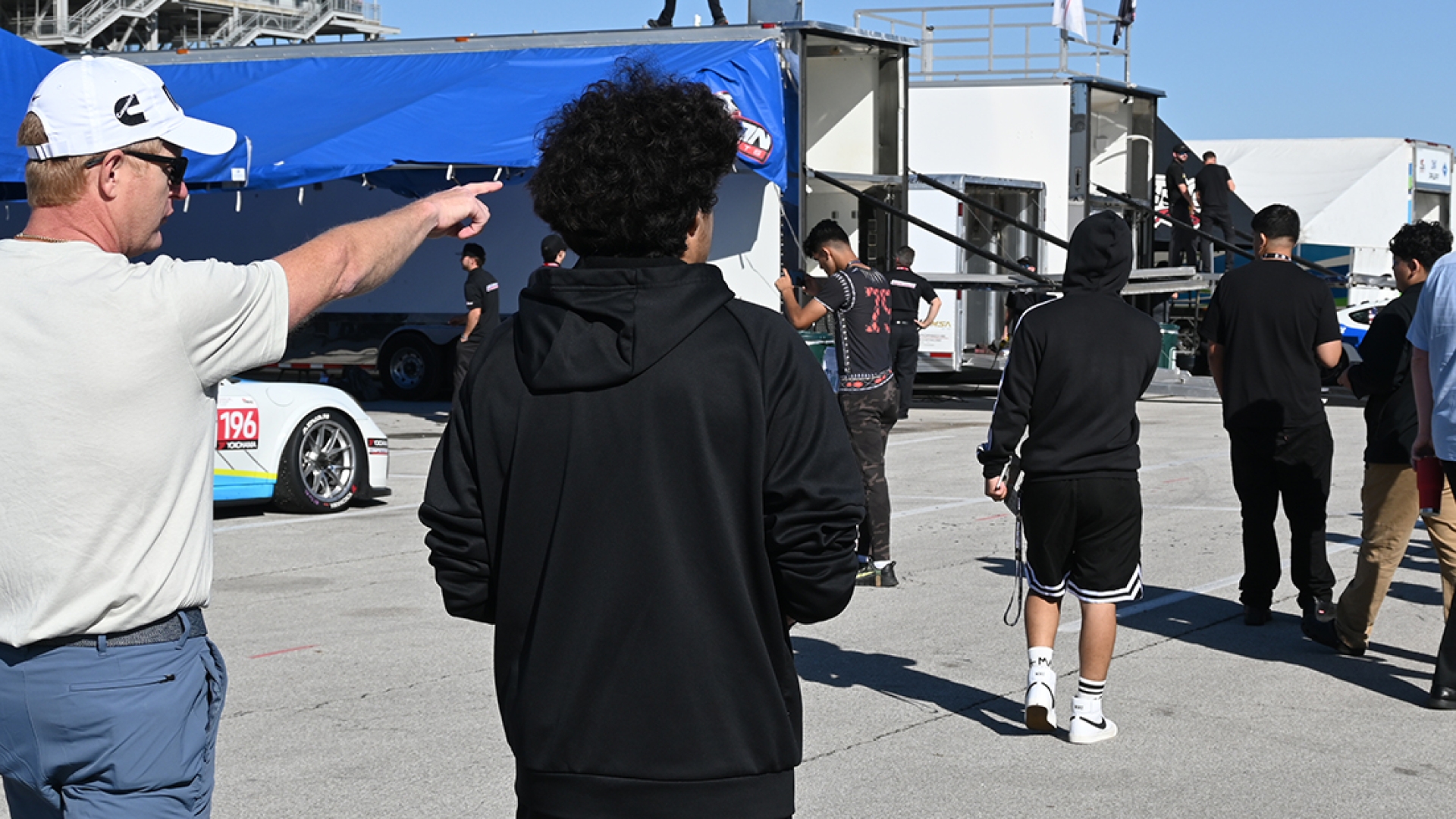 Cummins employee pointing out cars at track