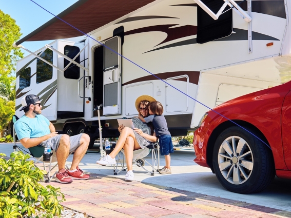 Family sitting outside RV in driveway
